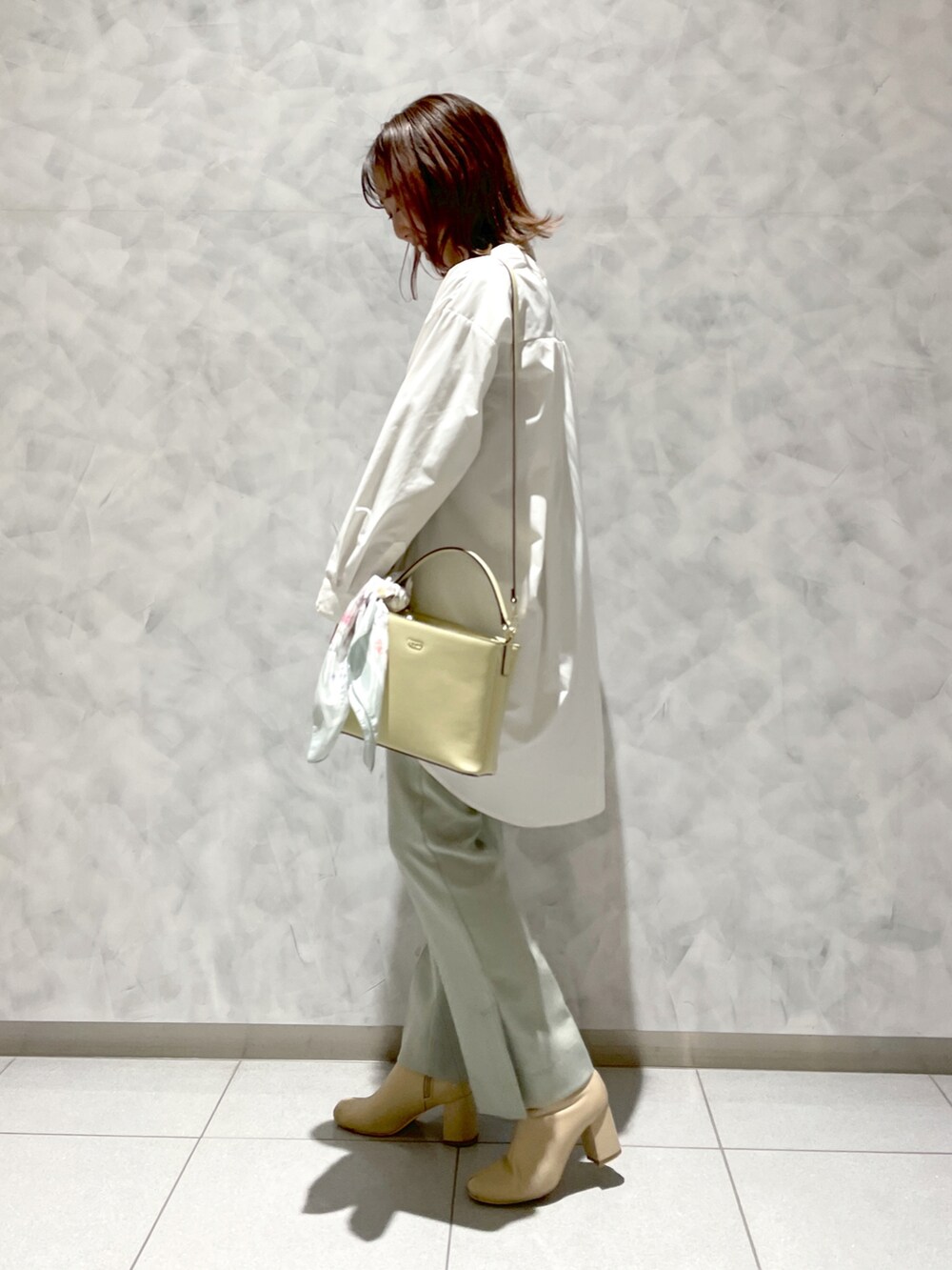 ホワイト系のブーツ、ホワイト系のシャツ/ブラウス、イエロー系のハンドバッグを着用したレディースの春コーディネートの3枚目の写真