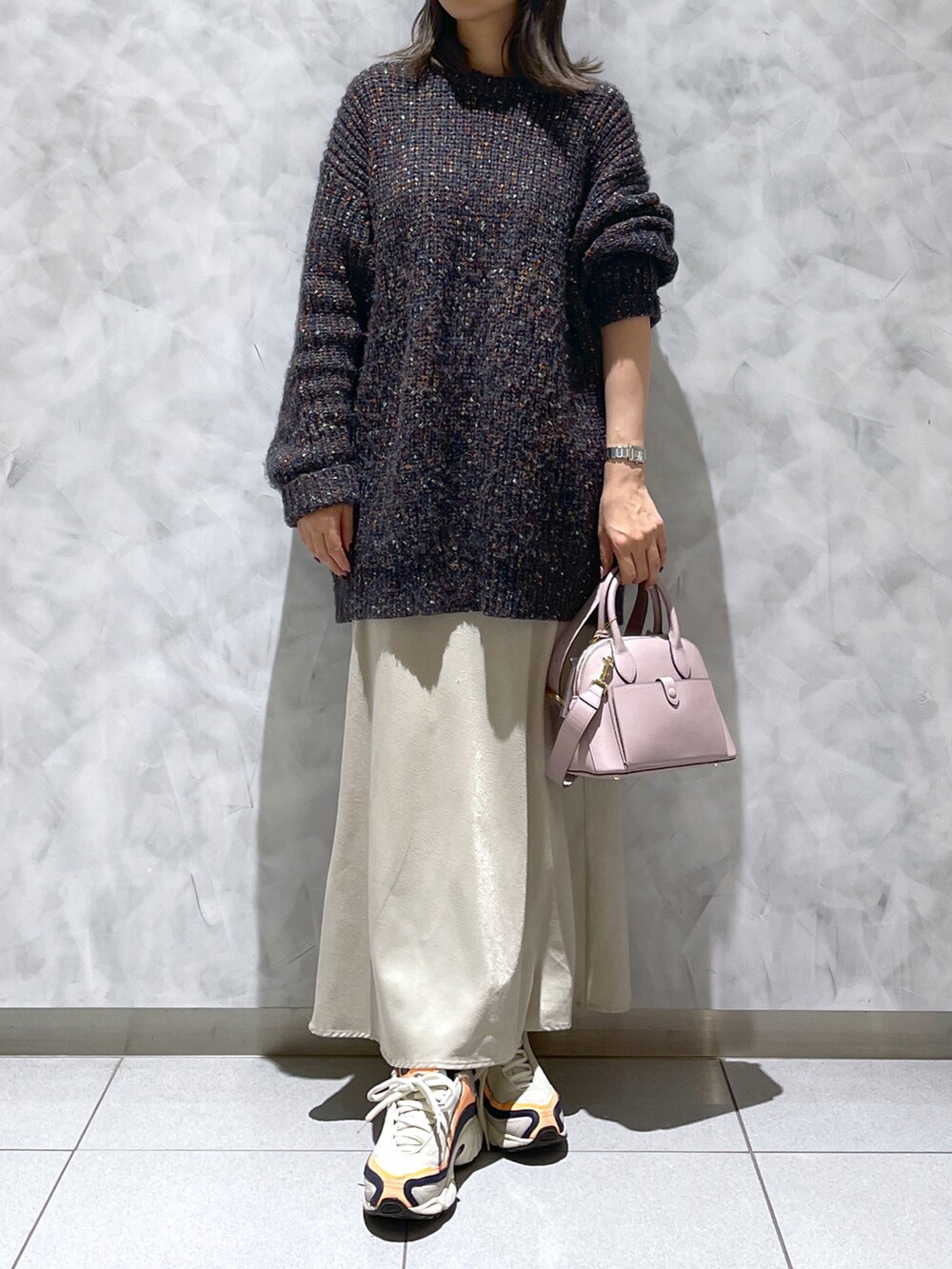 ピンク系のハンドバッグ、ブラック系のニット/セーター、ベージュ系の財布を着用したレディースの冬コーディネートの5枚目の写真