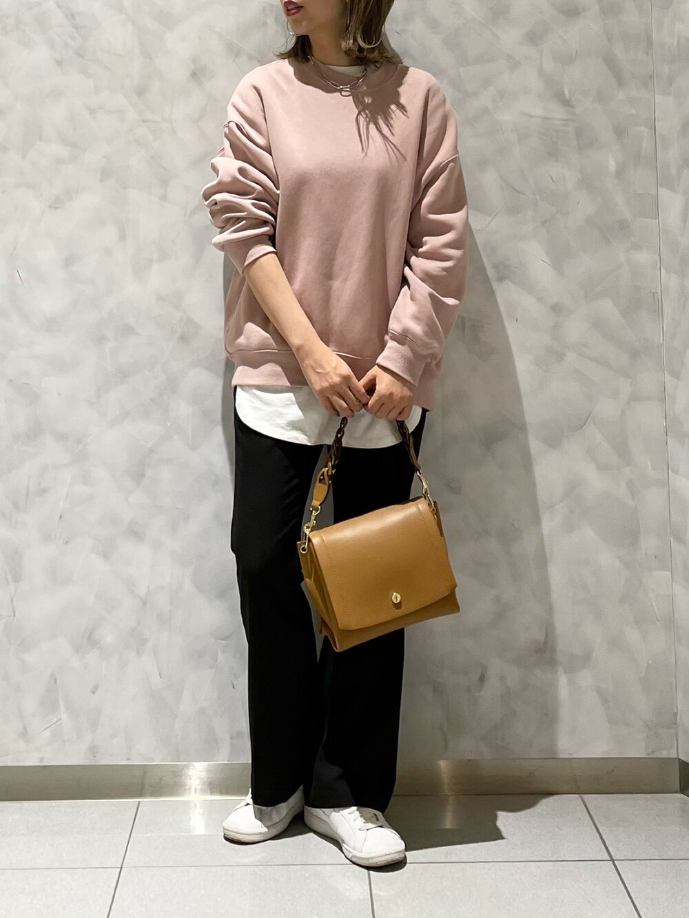 ブラック系のパンツ、イエロー系のハンドバッグを着用したレディースの冬コーディネートの2枚目の写真