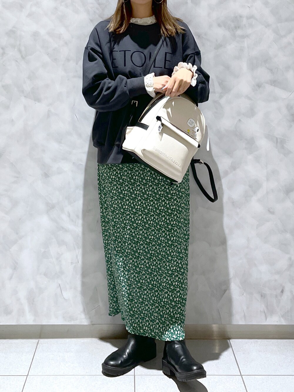 グリーン系のスカート、ホワイト系のバックパック/リュックを着用したレディースの春コーディネートの3枚目の写真