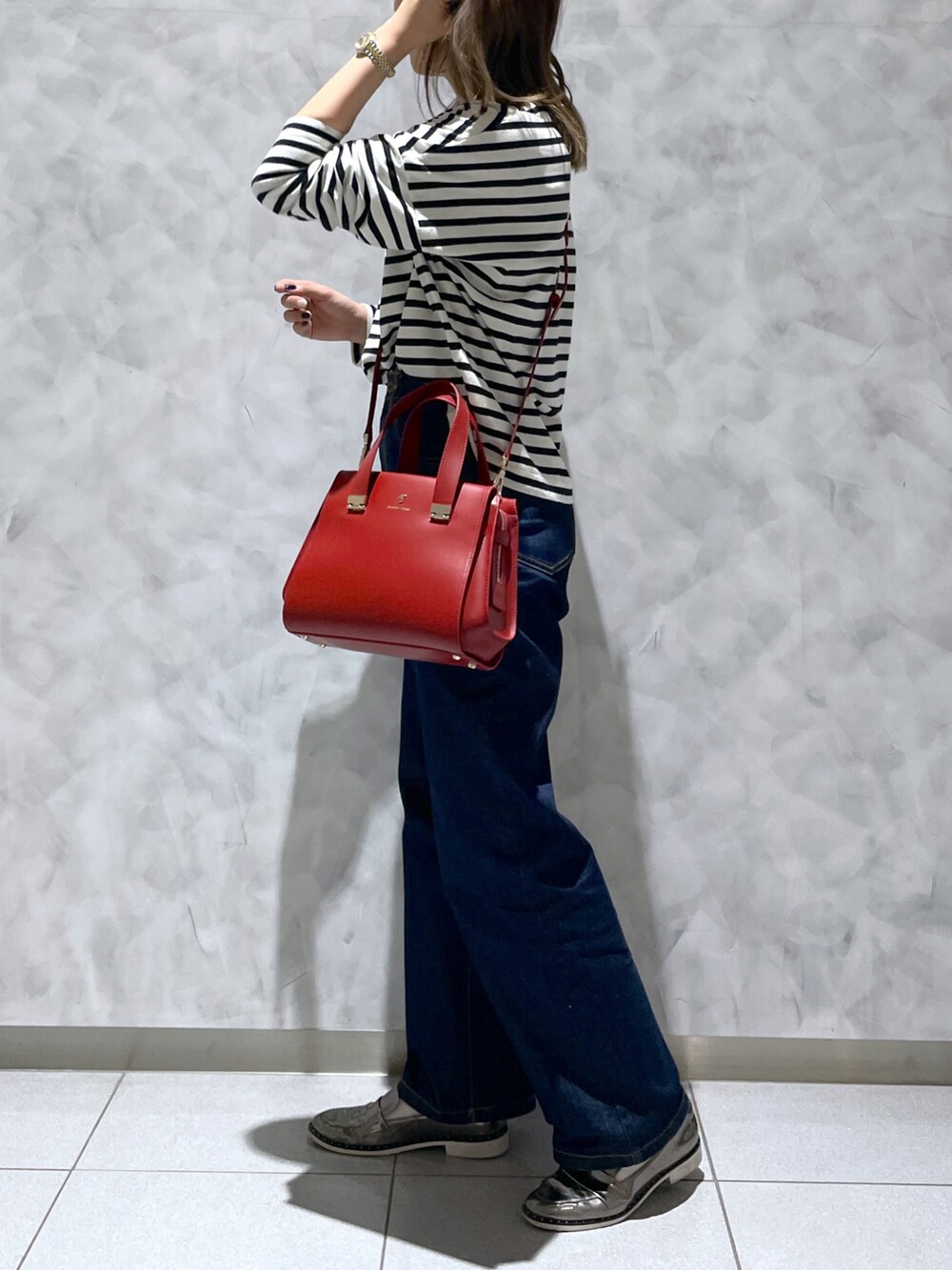 レッド系のハンドバッグを着用したレディースの冬コーディネートの3枚目の写真