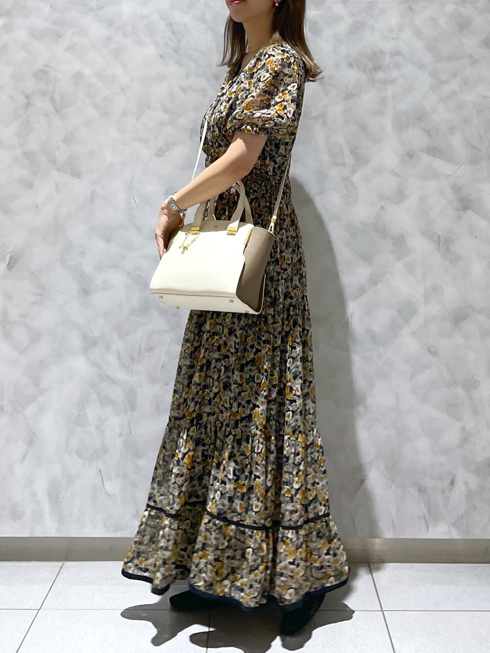 ホワイト系のハンドバッグを着用したレディースの春コーディネートの2枚目の写真