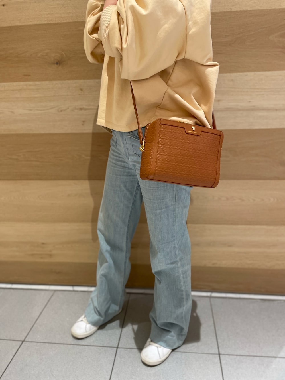 イエロー系のショルダーバッグ、イエロー系のスウェットを着用したレディースの冬コーディネートの3枚目の写真