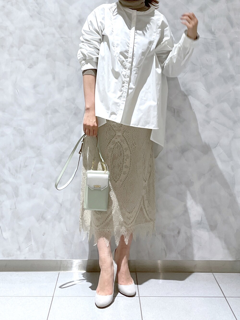 ホワイト系のスカート、グリーン系のショルダーバッグを着用したレディースの冬コーディネートの3枚目の写真