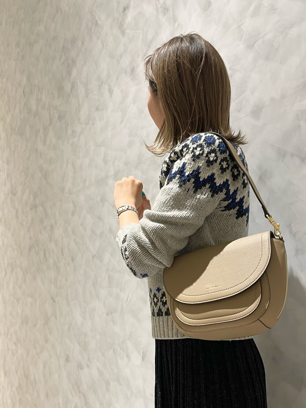 ブラック系のスカート、ベージュ系のショルダーバッグを着用したレディースの冬コーディネートの5枚目の写真