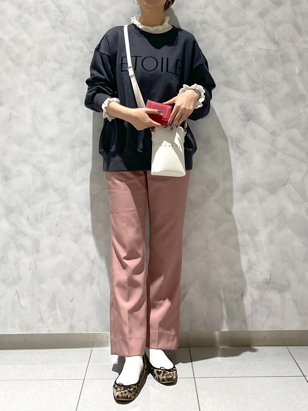 ブラウン系のシューズ、ブラック系のトップス、ホワイト系のショルダーバッグを着用したレディースの冬コーディネートの2枚目の写真