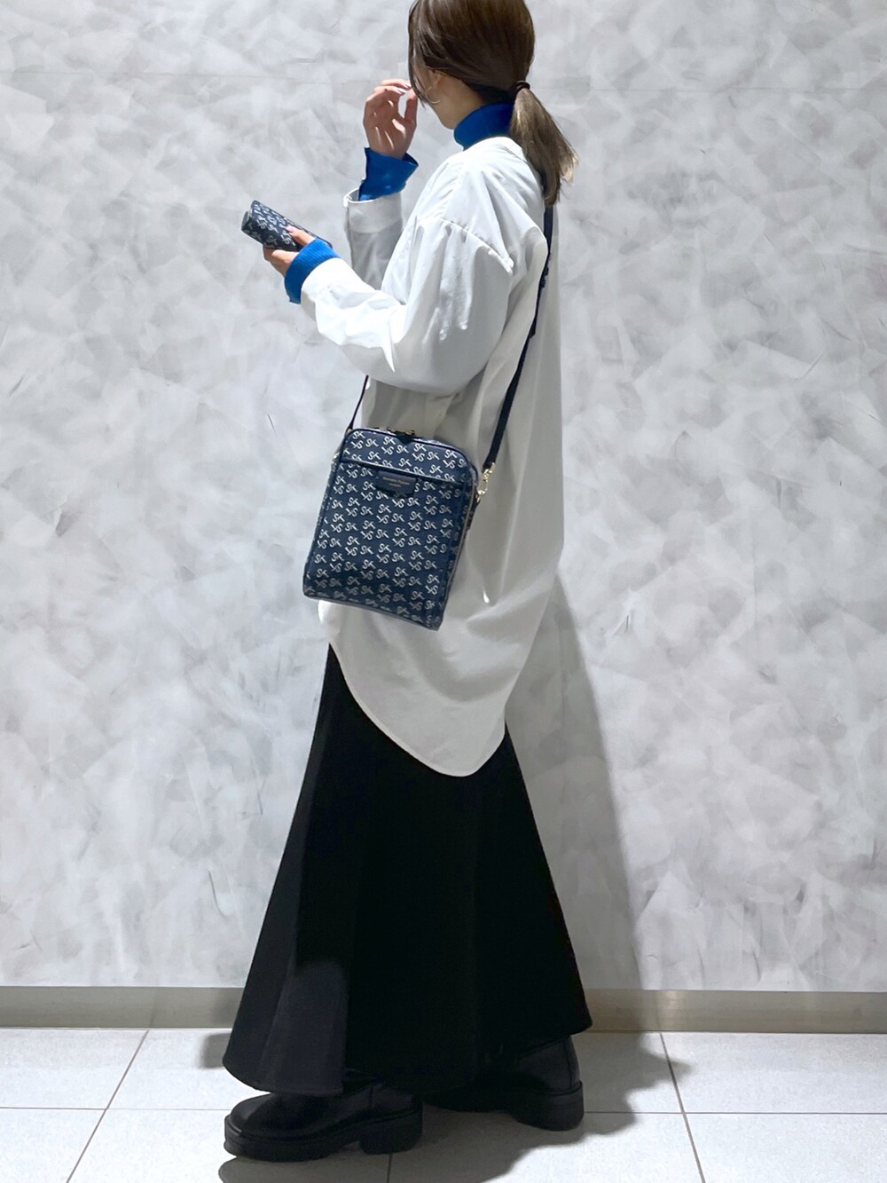 ブルー系のショルダーバッグ、ブルー系の財布を着用したレディースの春コーディネートの2枚目の写真