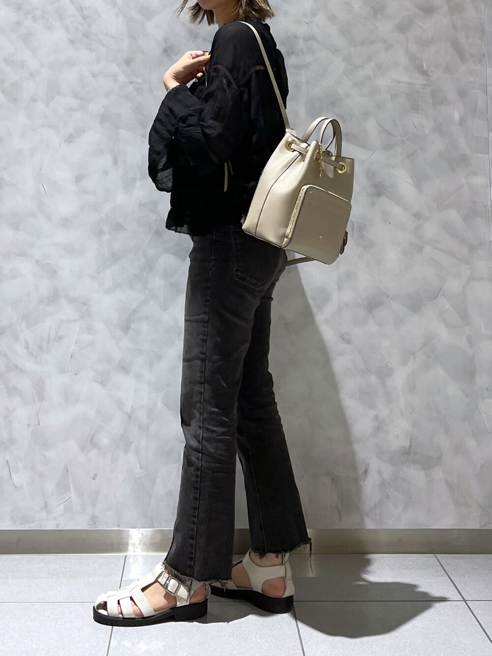 ベージュ系のバックパック/リュック、ブラック系のデニムパンツ、ブラック系のサンダルを着用したレディースの夏コーディネートの2枚目の写真