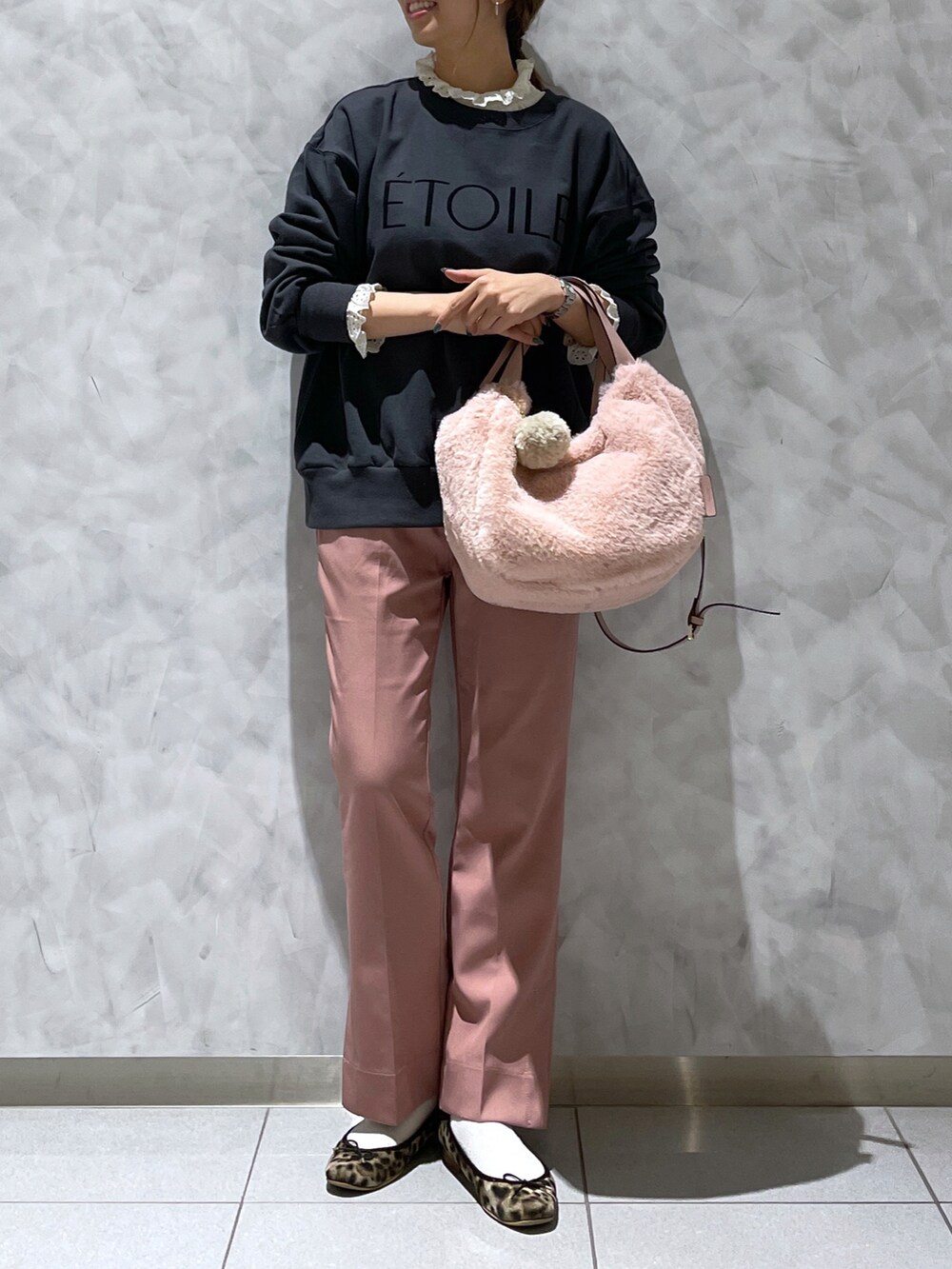 ピンク系のトートバッグ、ブラウン系のシューズ、ブラック系のトップスを着用したレディースの冬コーディネートの3枚目の写真