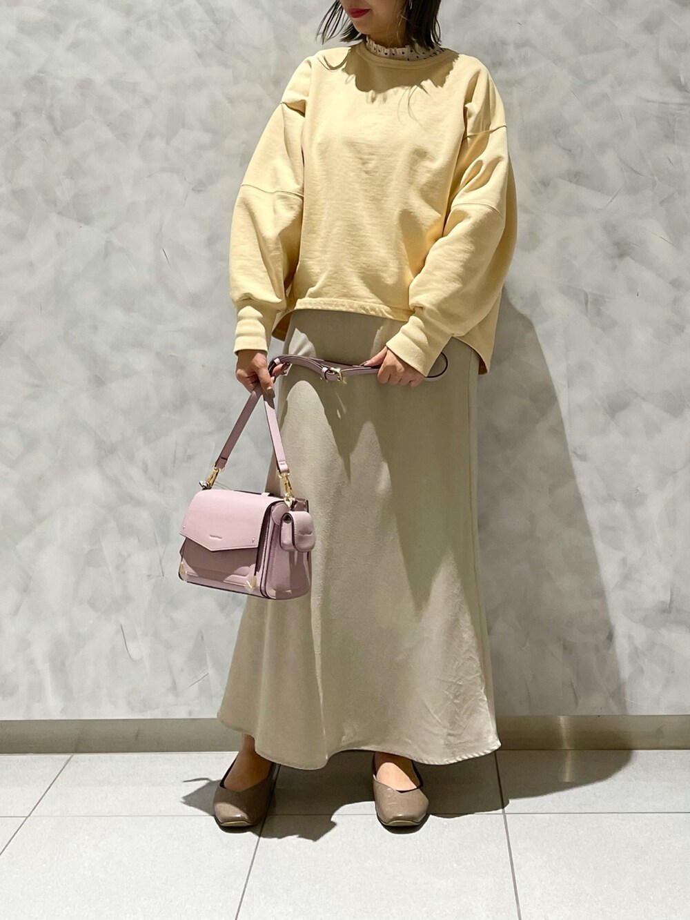 ピンク系のショルダーバッグ、イエロー系のスウェットを着用したレディースの冬コーディネートの3枚目の写真