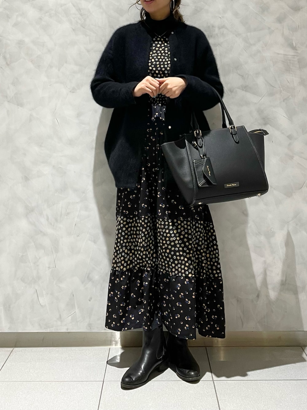 ブラック系のハンドバッグ、ブラック系のカーディガン/ボレロを着用したレディースの冬コーディネートの2枚目の写真