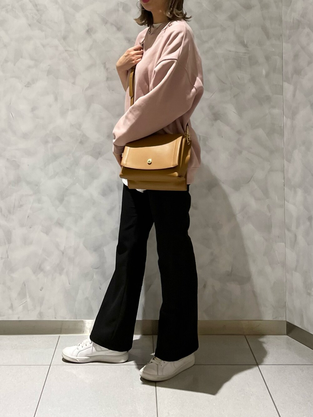 ブラック系のパンツ、イエロー系のハンドバッグを着用したレディースの冬コーディネートの5枚目の写真