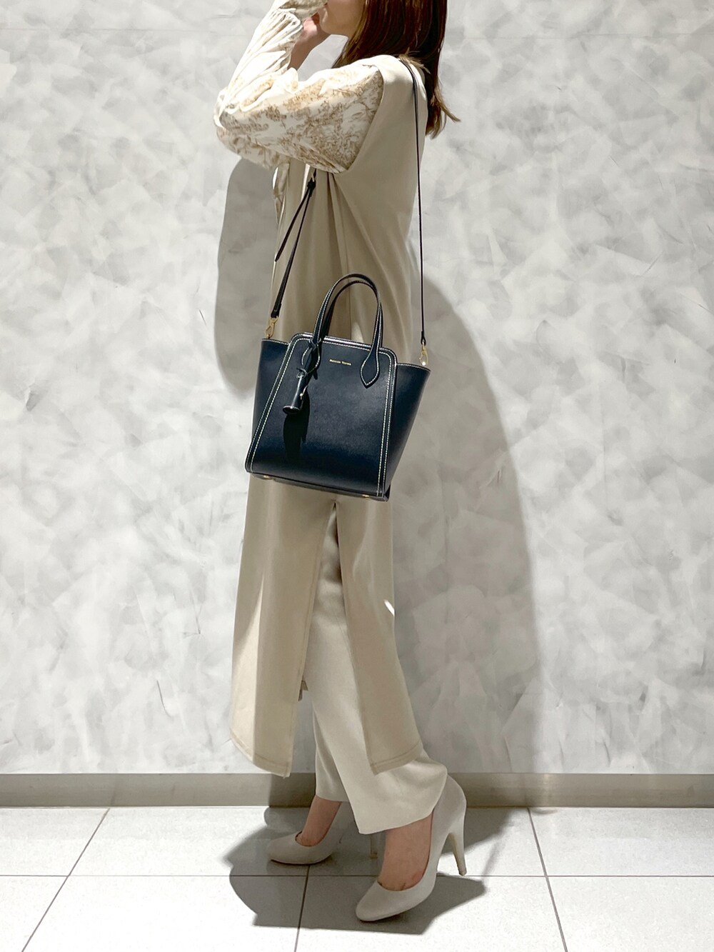 ブルー系のトートバッグを着用したレディースの冬コーディネートの2枚目の写真
