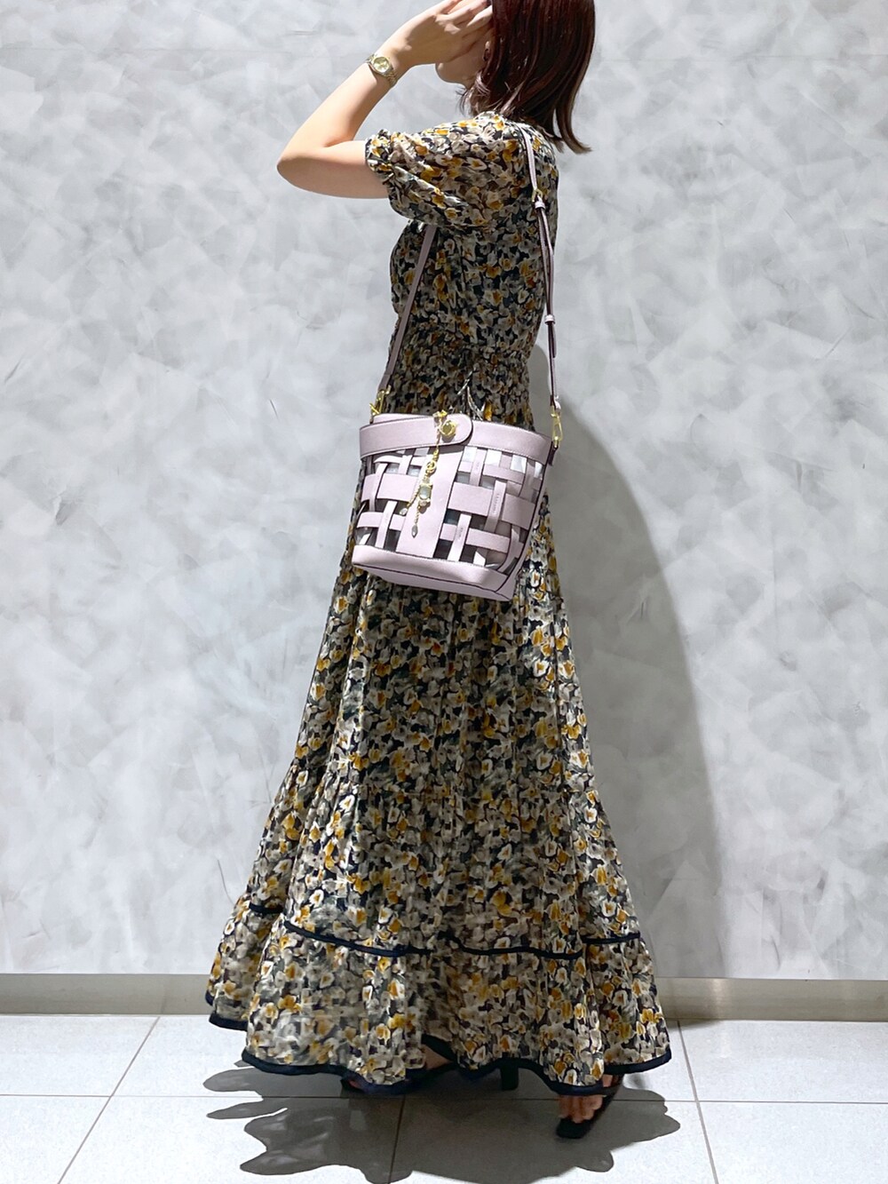 パープル系のハンドバッグ、その他のワンピースを着用したレディースの夏コーディネートの3枚目の写真