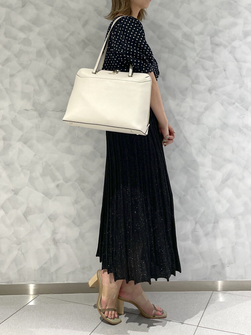 ホワイト系のトートバッグを着用したレディースの秋コーディネートの3枚目の写真