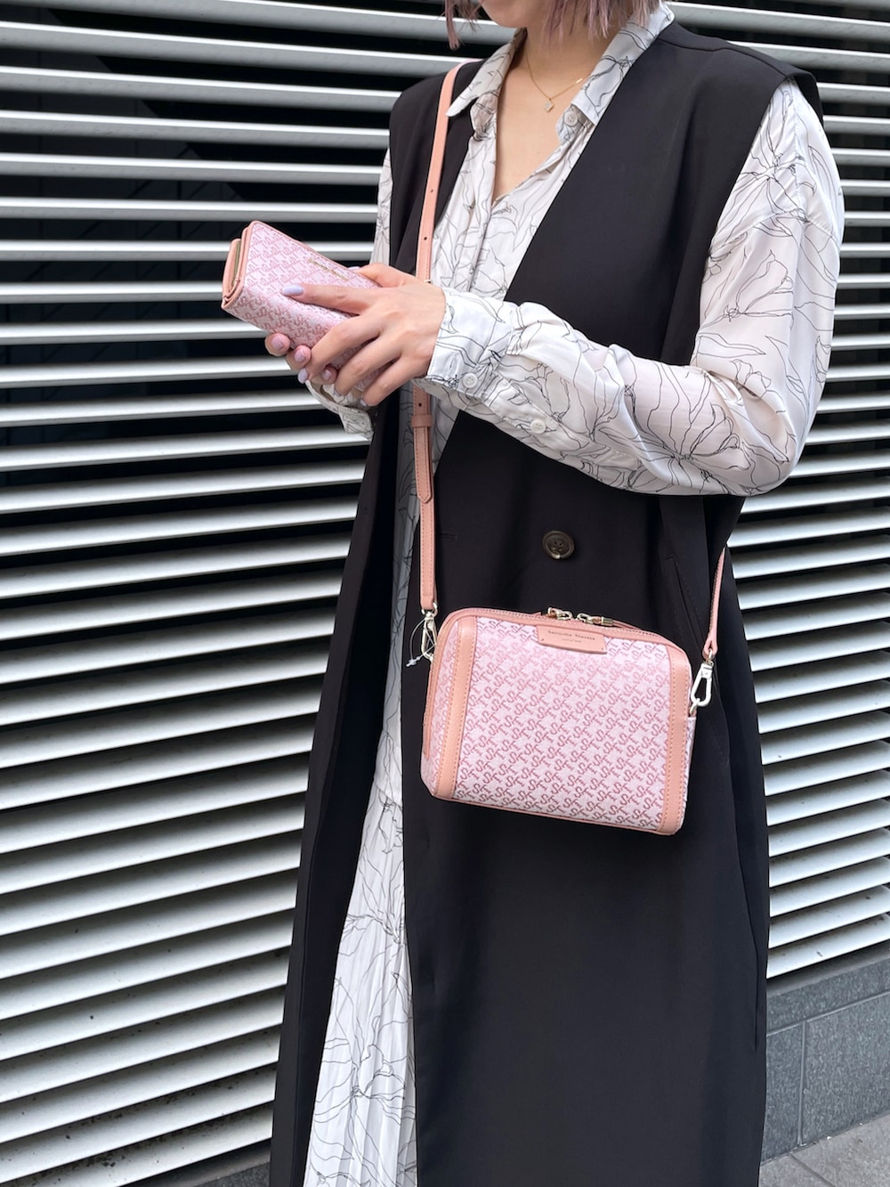 ピンク系のショルダーバッグ、ピンク系の財布を着用したレディースの夏コーディネートの2枚目の写真