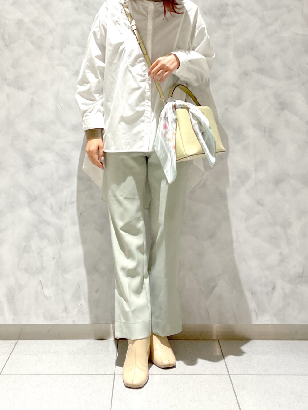 ホワイト系のブーツ、ホワイト系のシャツ/ブラウス、イエロー系のハンドバッグを着用したレディースの春コーディネートの2枚目の写真