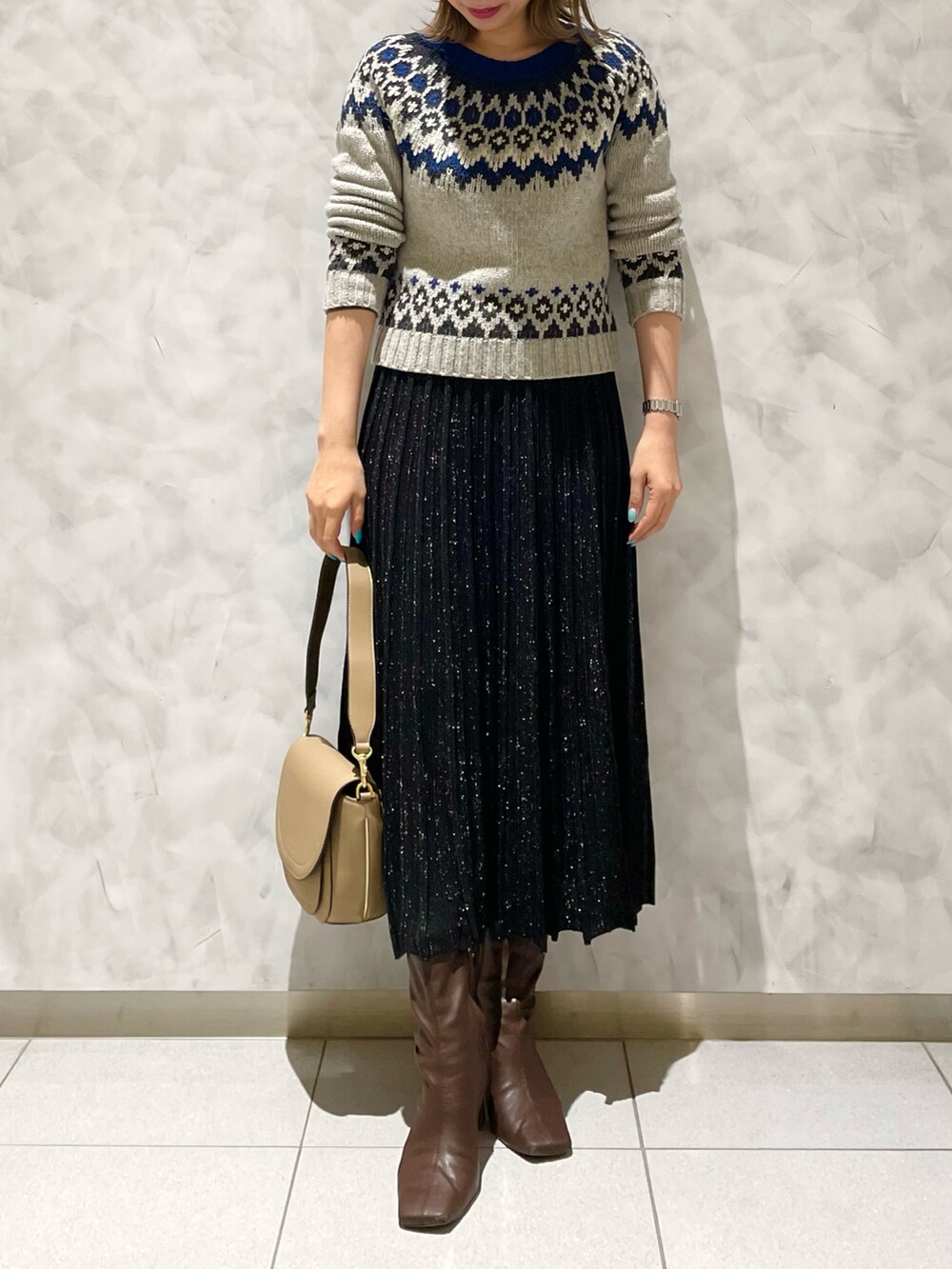 ブラック系のスカート、ベージュ系のショルダーバッグを着用したレディースの冬コーディネートの4枚目の写真