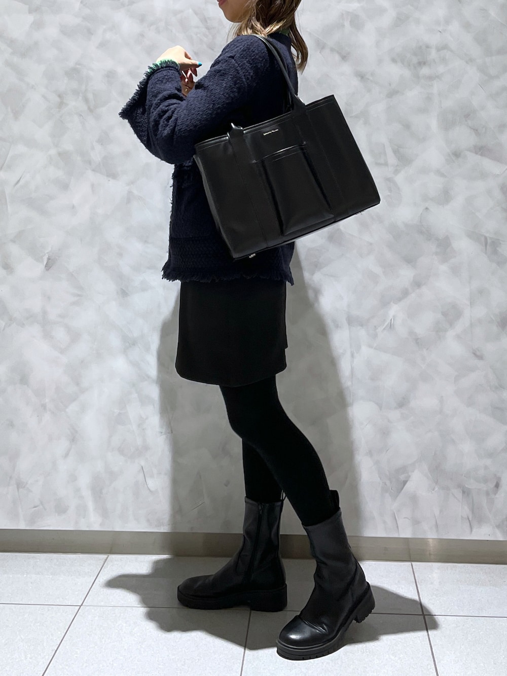 ブラック系のトートバッグを着用したレディースの春コーディネートの2枚目の写真