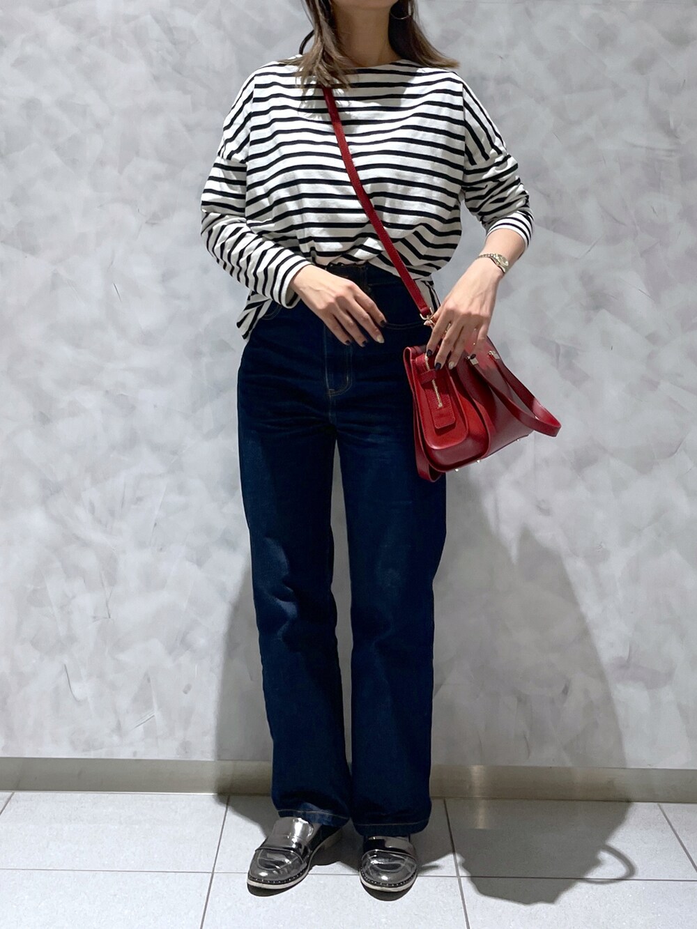 レッド系のハンドバッグを着用したレディースの冬コーディネートの2枚目の写真