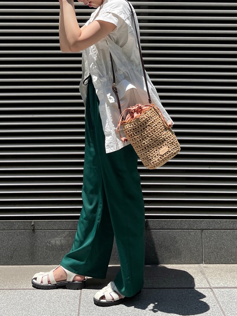 ブラック系のサンダル、グリーン系のその他パンツ、ピンク系のショルダーバッグを着用したレディースの夏コーディネートの2枚目の写真
