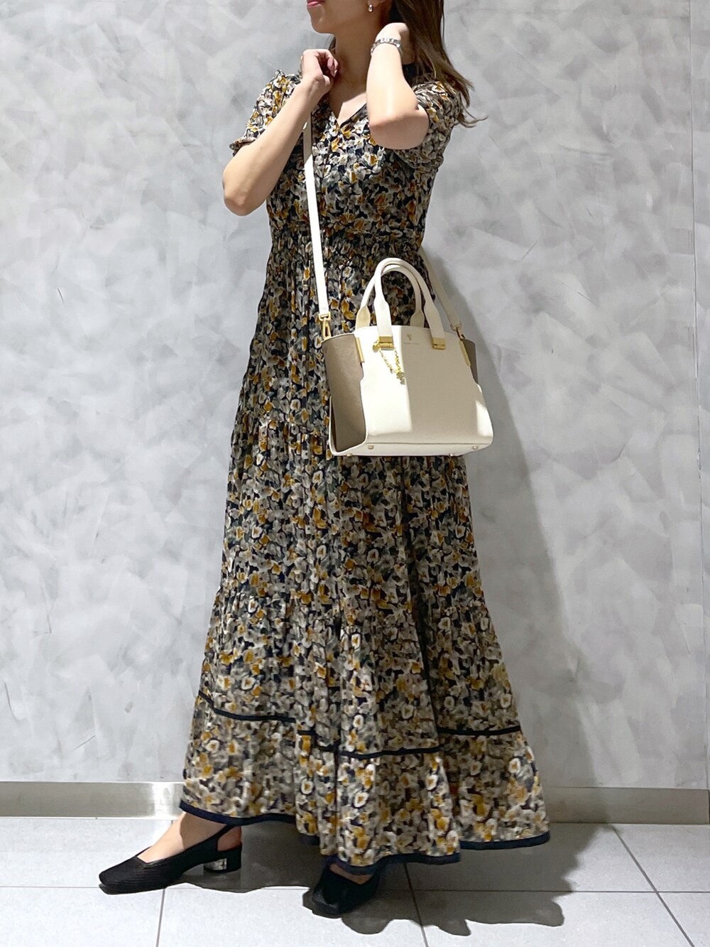 ホワイト系のハンドバッグを着用したレディースの春コーディネートの3枚目の写真