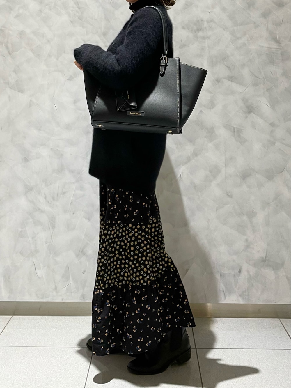 ブラック系のハンドバッグ、ブラック系のカーディガン/ボレロを着用したレディースの冬コーディネートの3枚目の写真