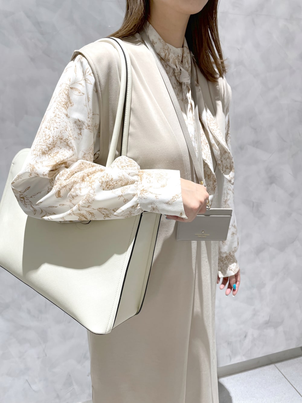 ホワイト系のトートバッグ、ベージュ系の財布/小物を着用したレディースの冬コーディネートの3枚目の写真