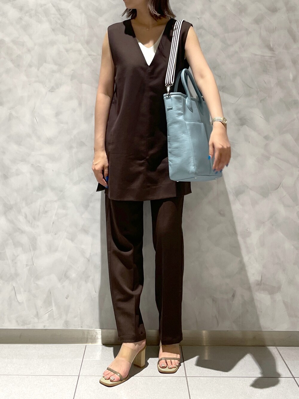 ブルー系のトートバッグ、グリーン系のサンダルを着用したレディースの夏コーディネートの3枚目の写真