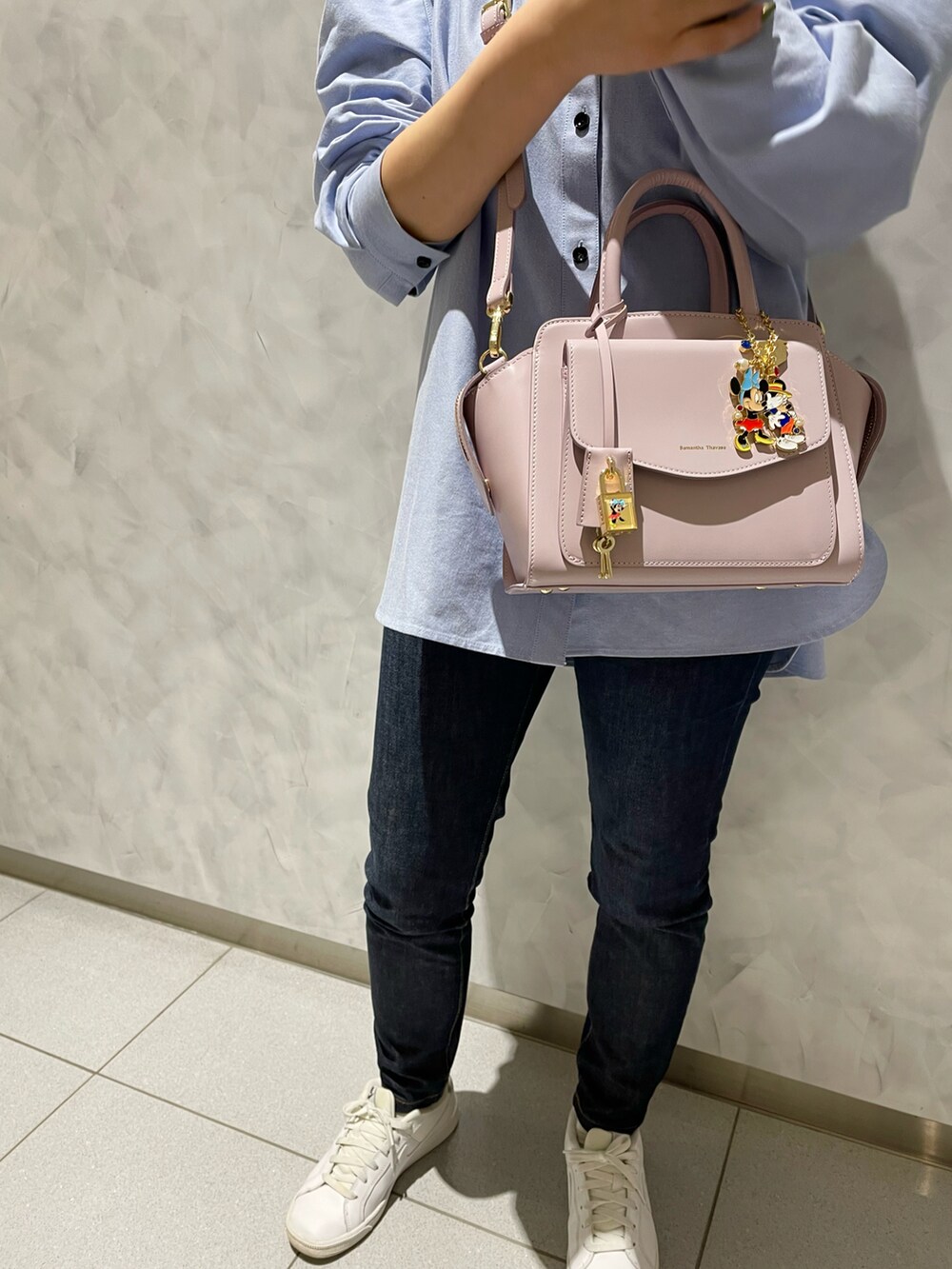 ピンク系のハンドバッグ、ブルー系のデニムパンツを着用したレディースの冬コーディネートの3枚目の写真