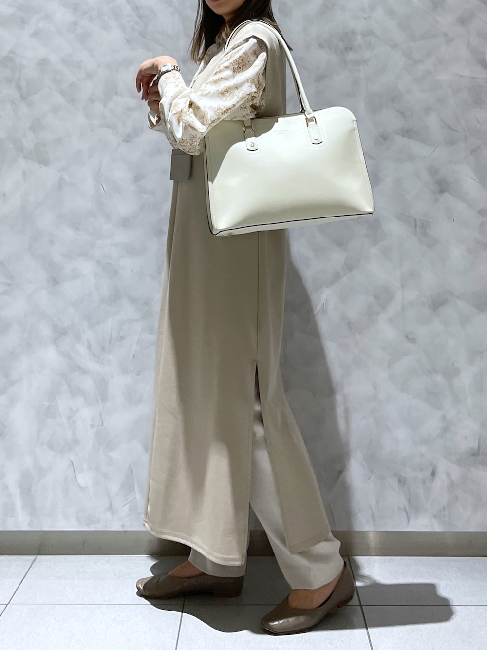 ホワイト系のトートバッグ、ベージュ系の財布/小物を着用したレディースの冬コーディネートの2枚目の写真