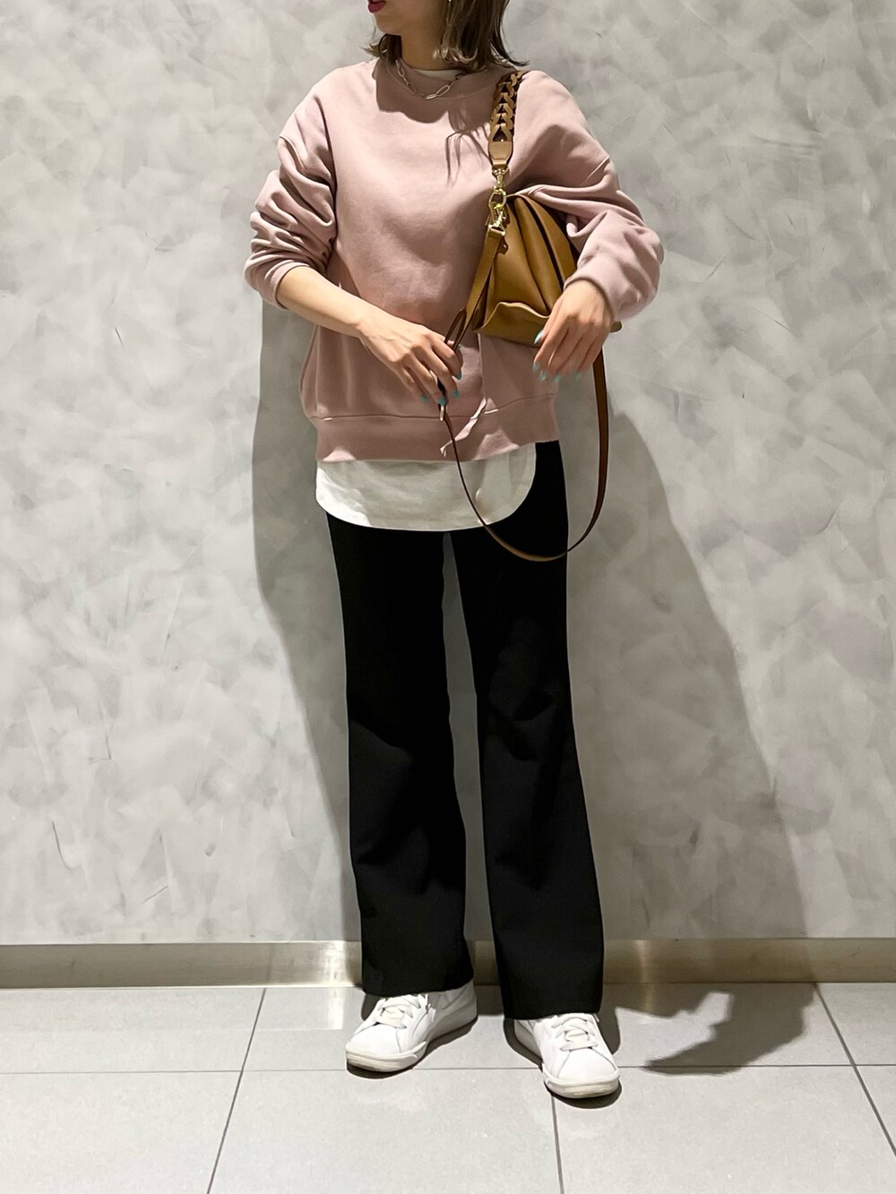 ブラック系のパンツ、イエロー系のハンドバッグを着用したレディースの冬コーディネートの3枚目の写真