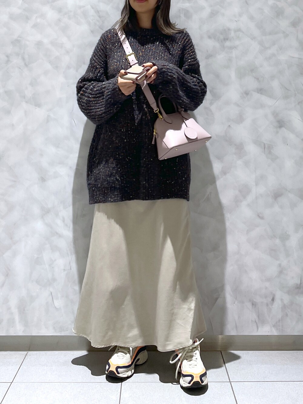 ピンク系のハンドバッグ、ブラック系のニット/セーター、ベージュ系の財布を着用したレディースの冬コーディネートの2枚目の写真