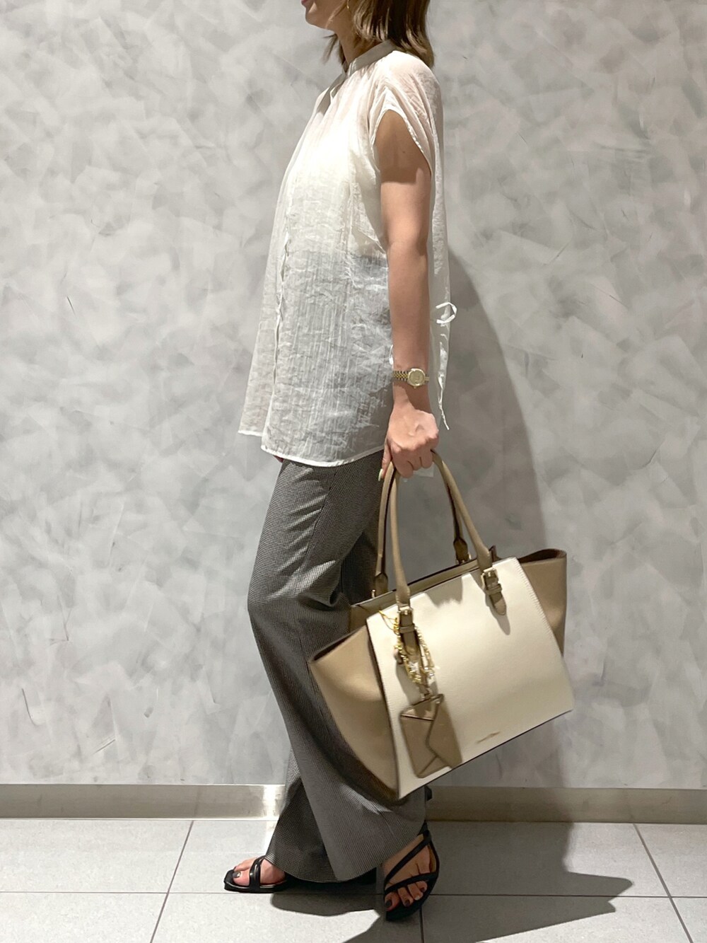 ベージュ系のハンドバッグを着用したレディースの夏コーディネートの2枚目の写真