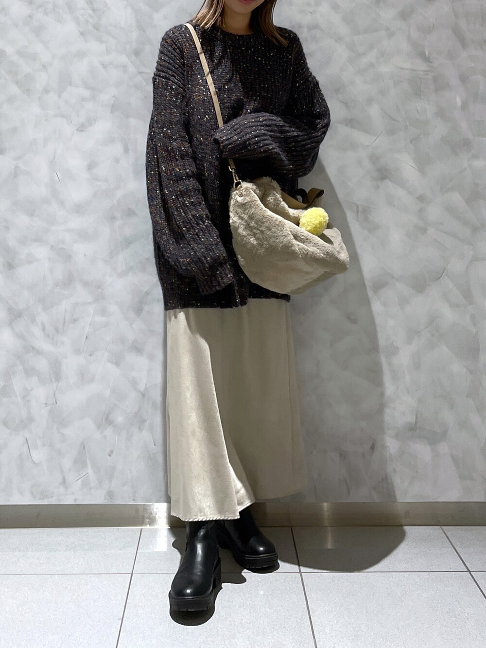 ブラック系のニット/セーター、ベージュ系のトートバッグを着用したレディースの秋コーディネートの3枚目の写真