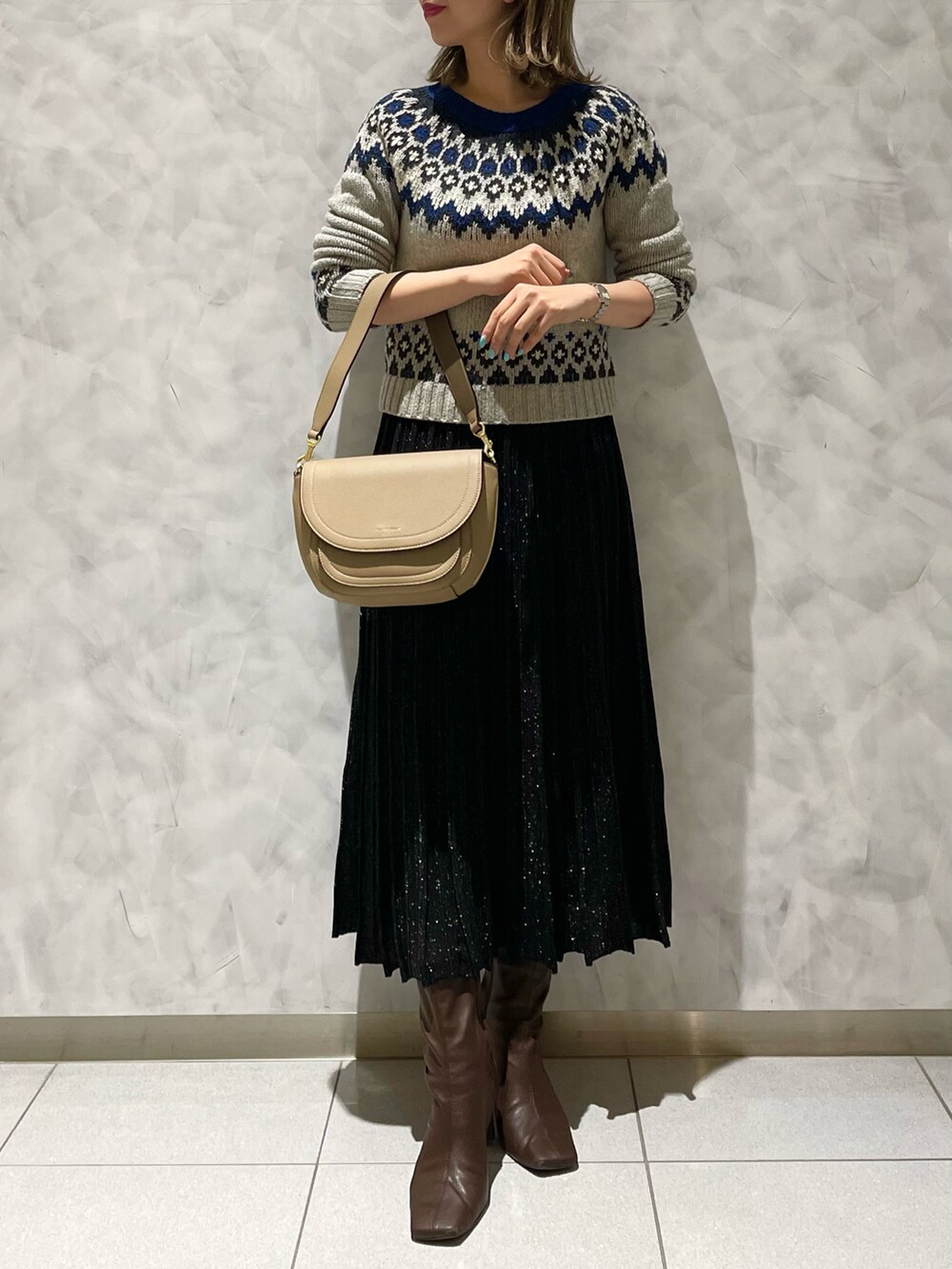 ブラック系のスカート、ベージュ系のショルダーバッグを着用したレディースの冬コーディネートの3枚目の写真