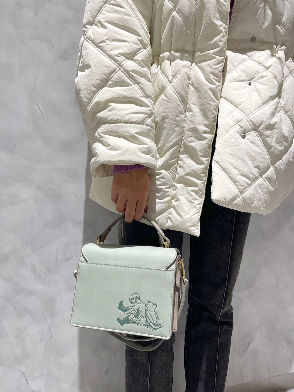 ホワイト系のその他アウター、グリーン系のショルダーバッグを着用したレディースの冬コーディネートの3枚目の写真