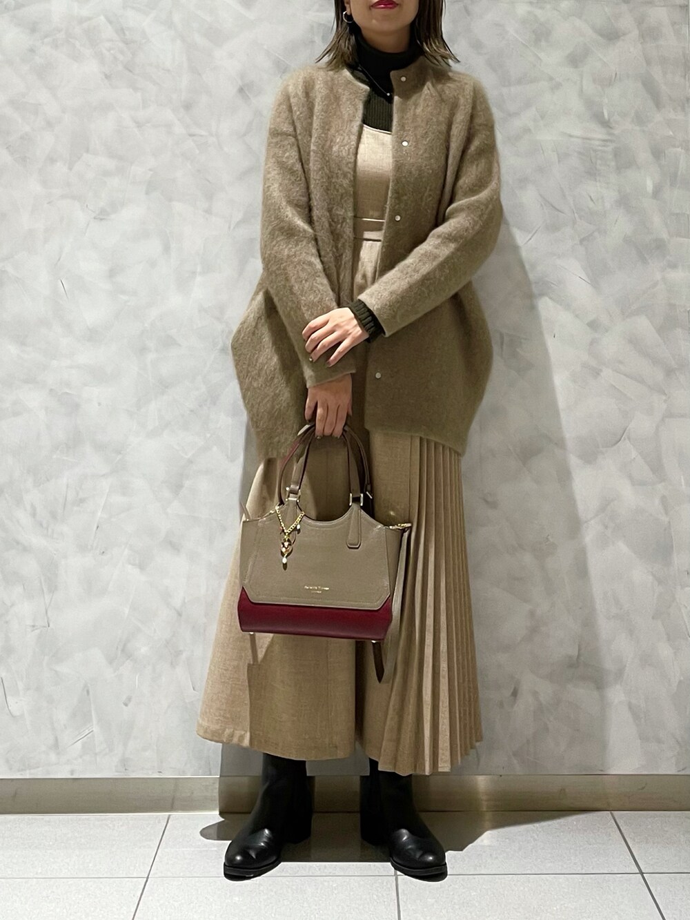 ベージュ系のワンピース/ドレス、ベージュ系のトートバッグ、ベージュ系のカーディガン/ボレロを着用したレディースの冬コーディネートの2枚目の写真