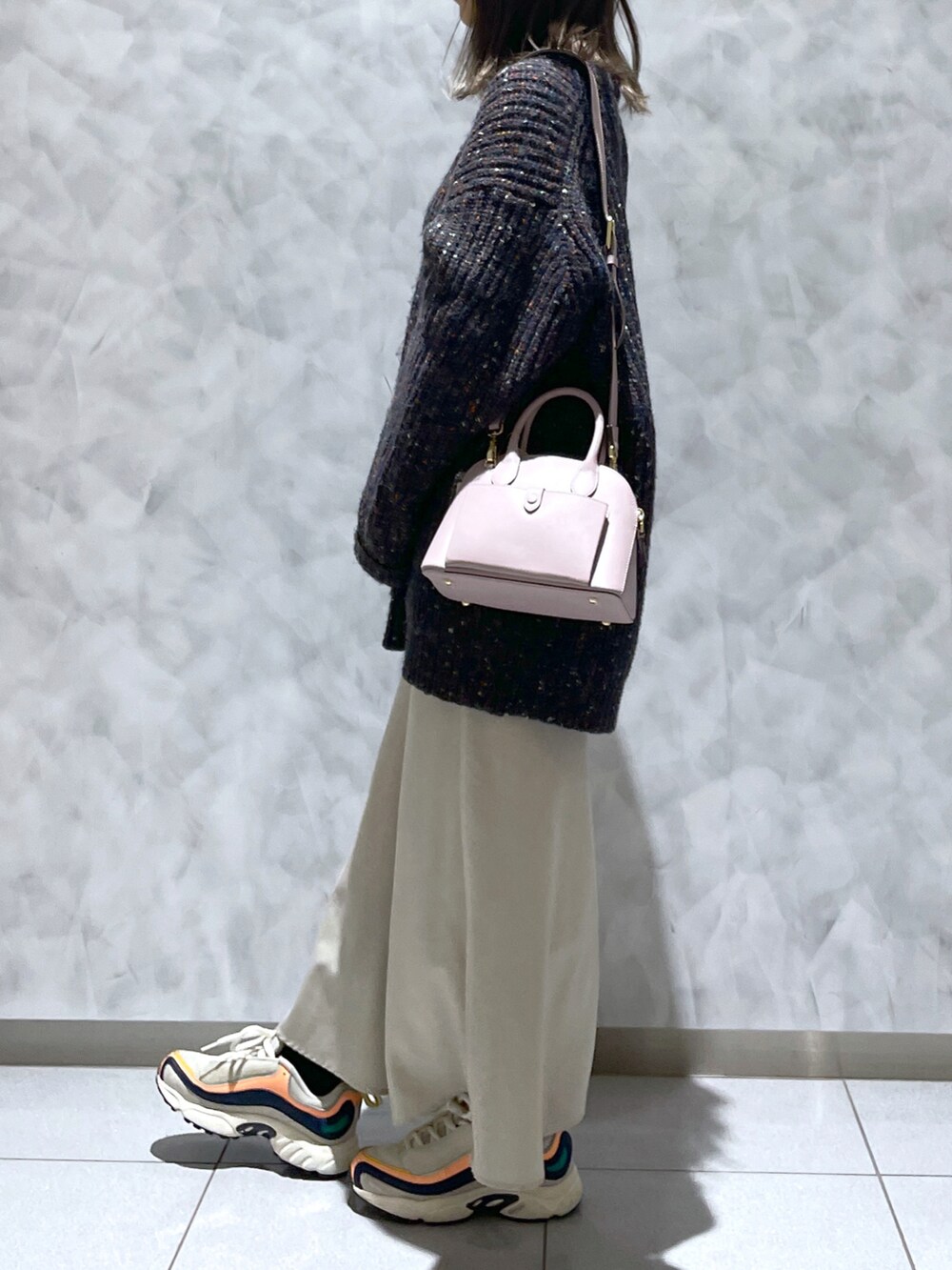 ピンク系のハンドバッグ、ブラック系のニット/セーター、ベージュ系の財布を着用したレディースの冬コーディネートの4枚目の写真