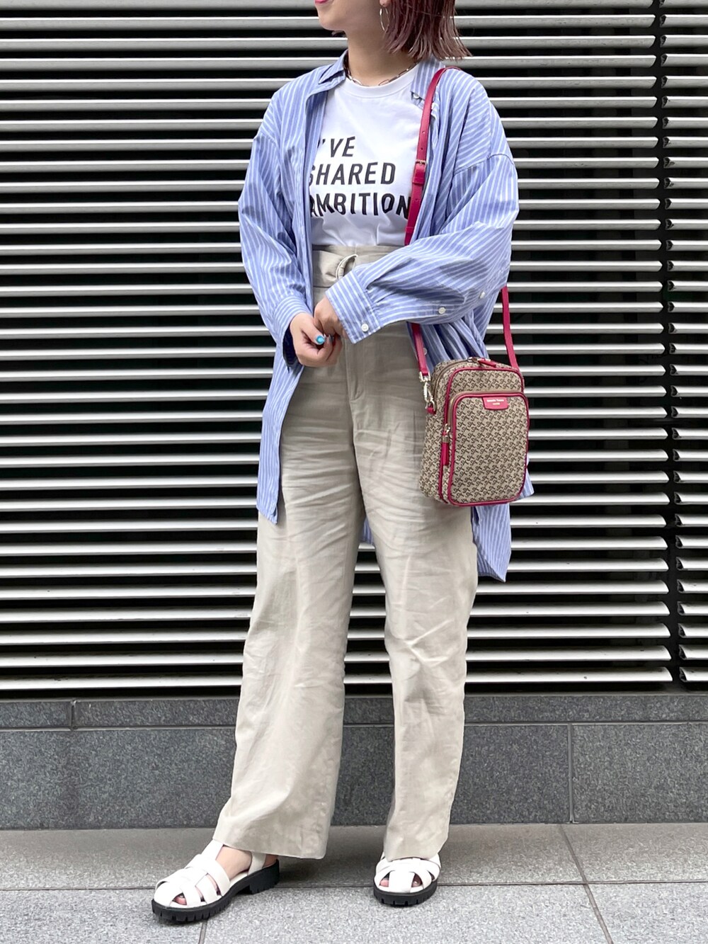 ブラック系のサンダル、ベージュ系のパンツ、ピンク系のショルダーバッグを着用したレディースの春コーディネートの3枚目の写真