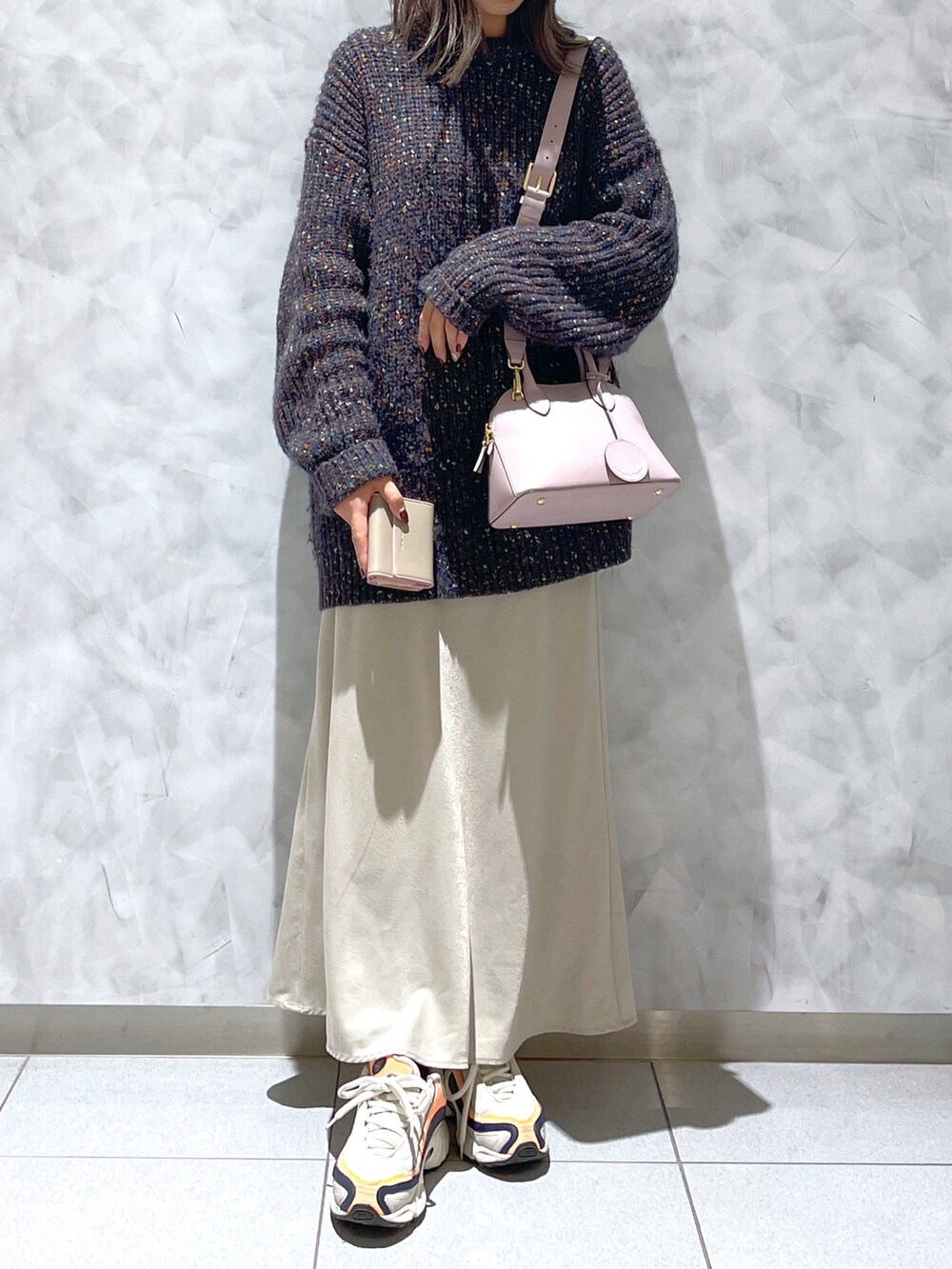 ピンク系のハンドバッグ、ブラック系のニット/セーター、ベージュ系の財布を着用したレディースの冬コーディネートの3枚目の写真
