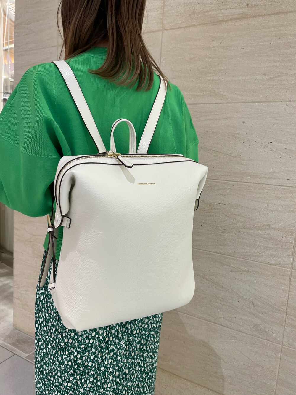 グリーン系のスカート、グリーン系のスウェット、ホワイト系のバックパック/リュックを着用したレディースの冬コーディネートの2枚目の写真