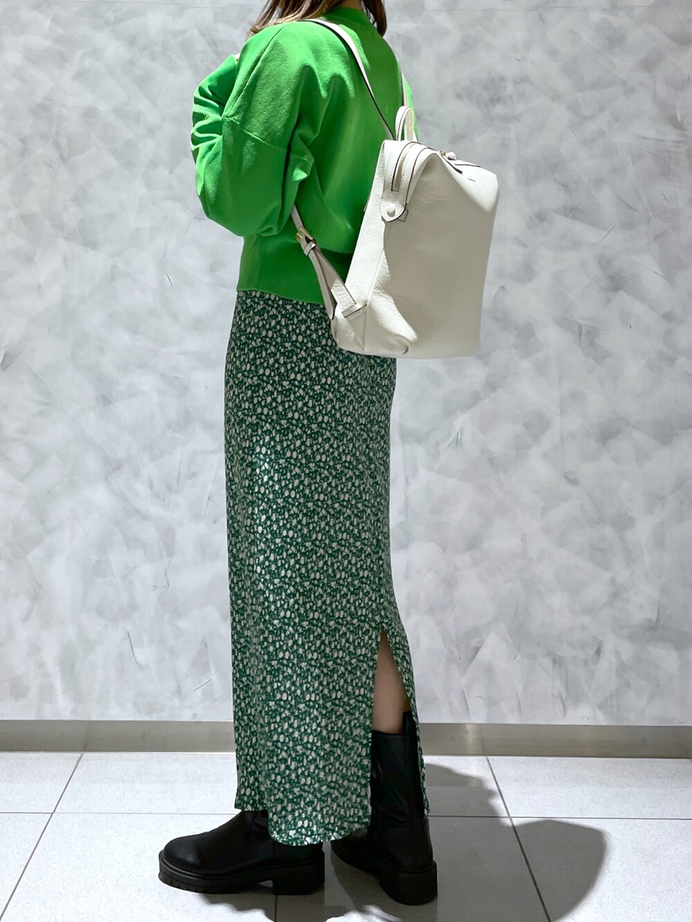 グリーン系のスカート、グリーン系のスウェット、ホワイト系のバックパック/リュックを着用したレディースの冬コーディネートの3枚目の写真