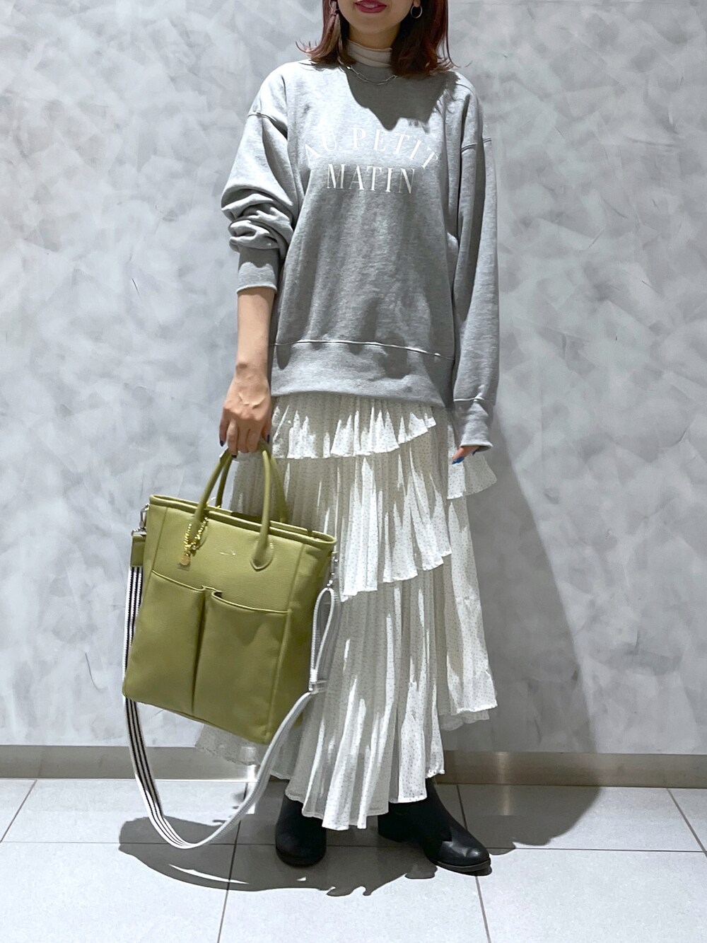 グリーン系のトートバッグ、グレー系のスウェットを着用したレディースの春コーディネートの2枚目の写真