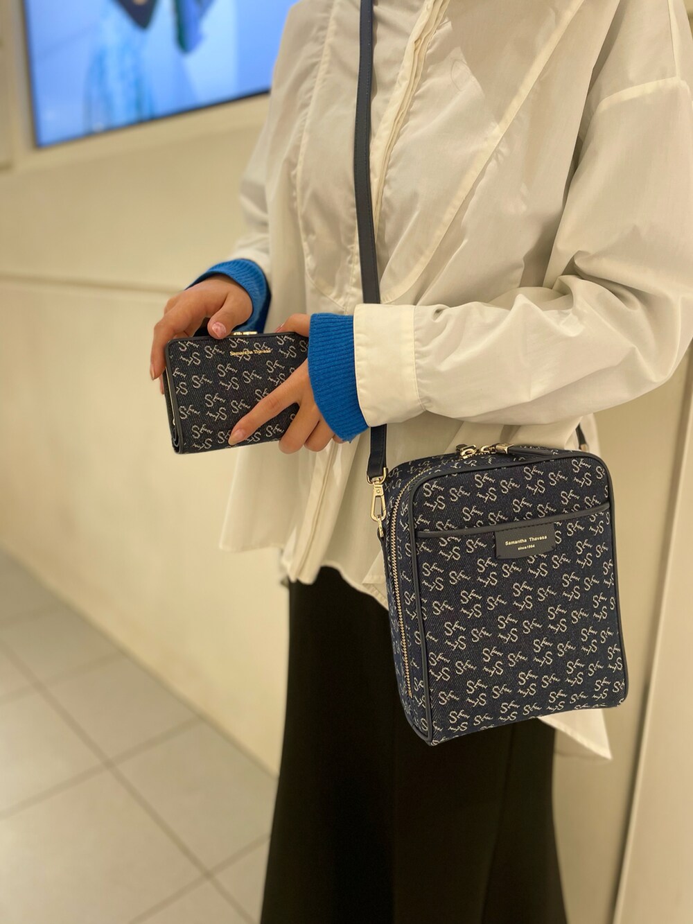 ブルー系のショルダーバッグ、ブルー系の財布を着用したレディースの春コーディネートの4枚目の写真