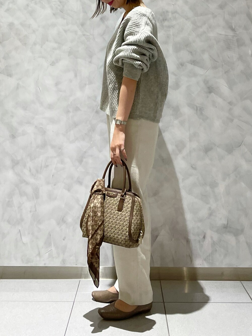 ベージュ系のシューズ、ブラウン系のハンドバッグ、ブラウン系のバンダナ/スカーフを着用したレディースの冬コーディネートの2枚目の写真