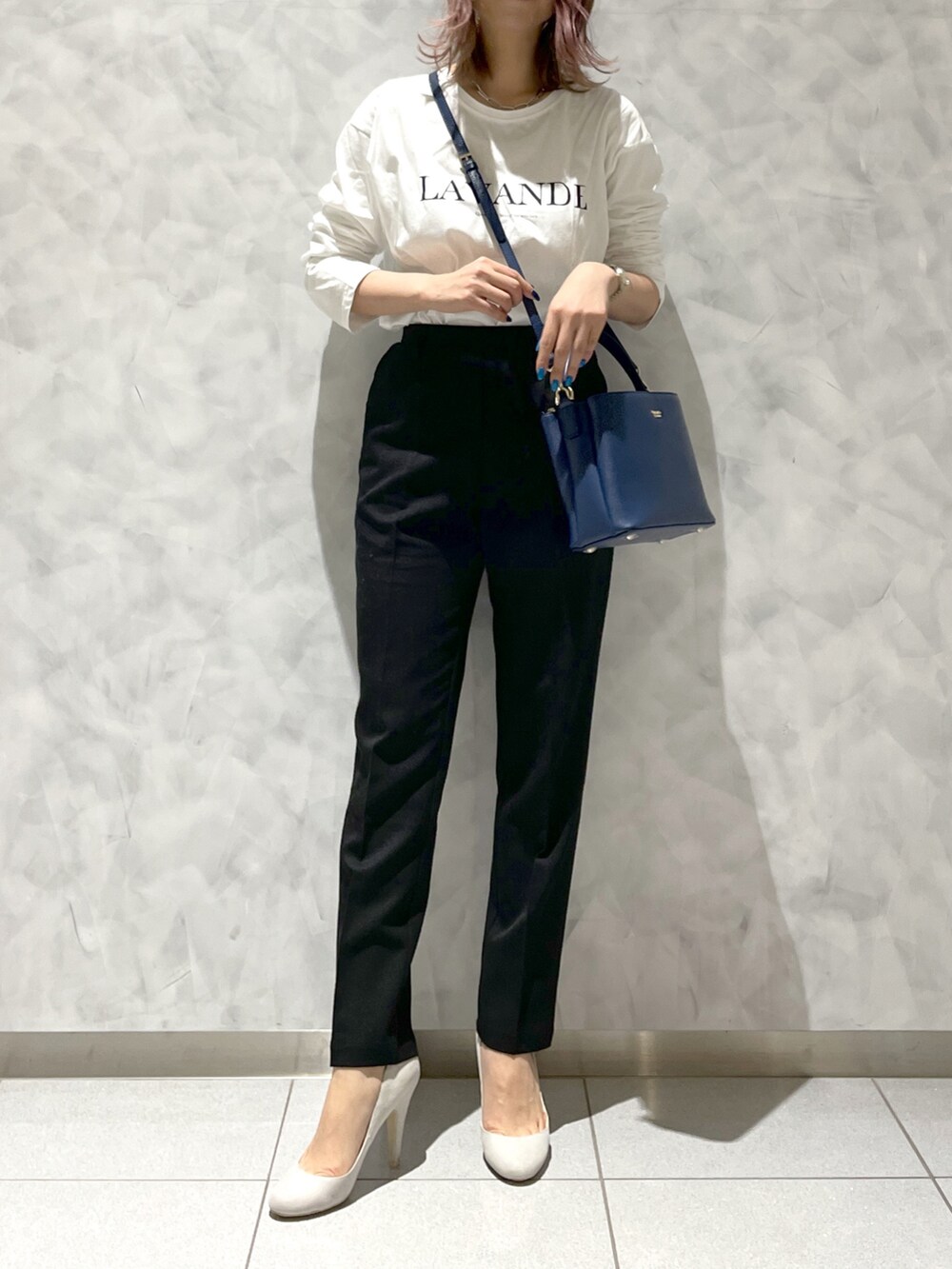 ブルー系のハンドバッグを着用したレディースの春コーディネートの2枚目の写真