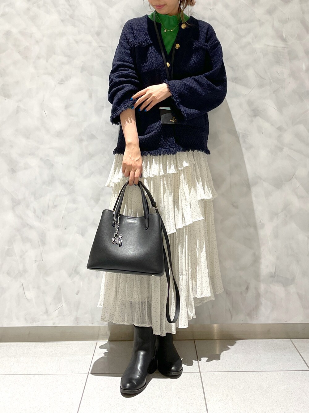 ホワイト系のスカート、ブルー系のジャケット/アウター、ブラック系のハンドバッグを着用したレディースの春コーディネートの3枚目の写真