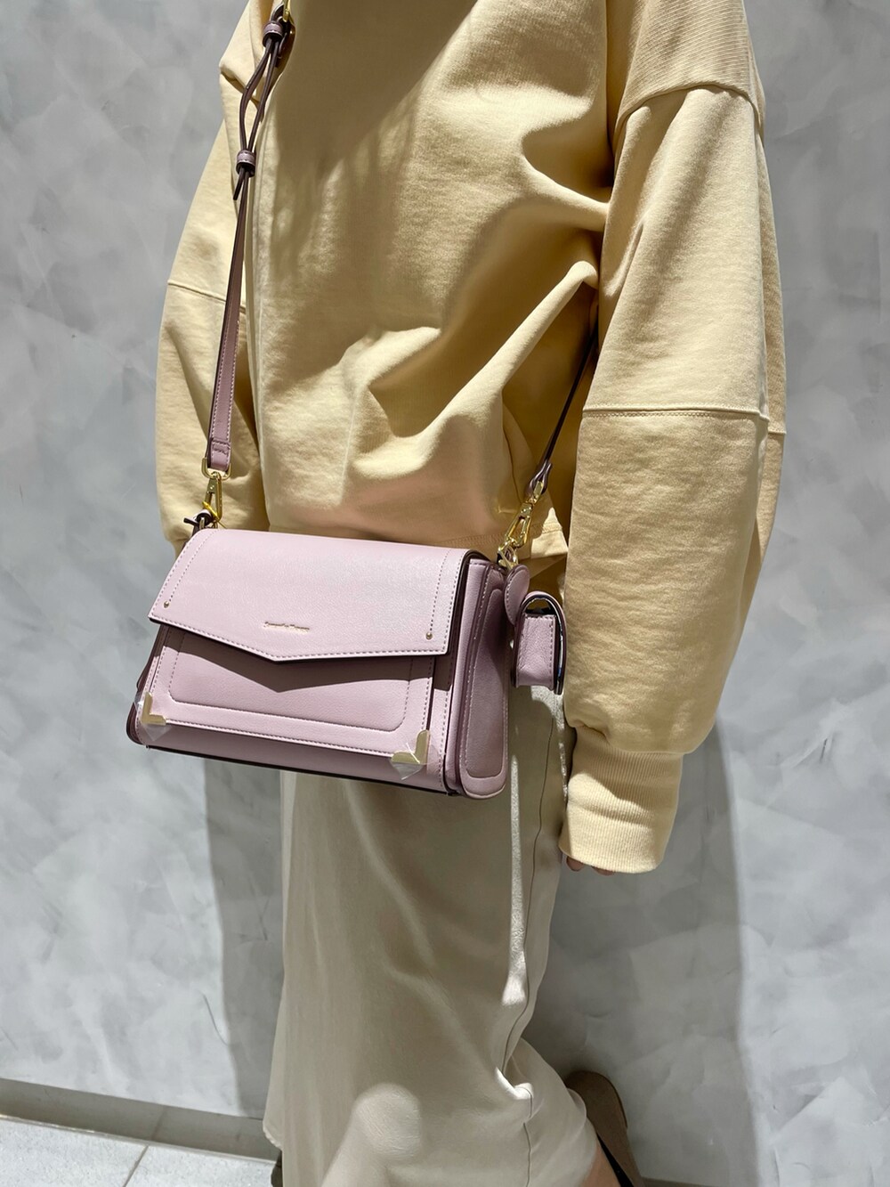 ピンク系のショルダーバッグ、イエロー系のスウェットを着用したレディースの冬コーディネートの4枚目の写真