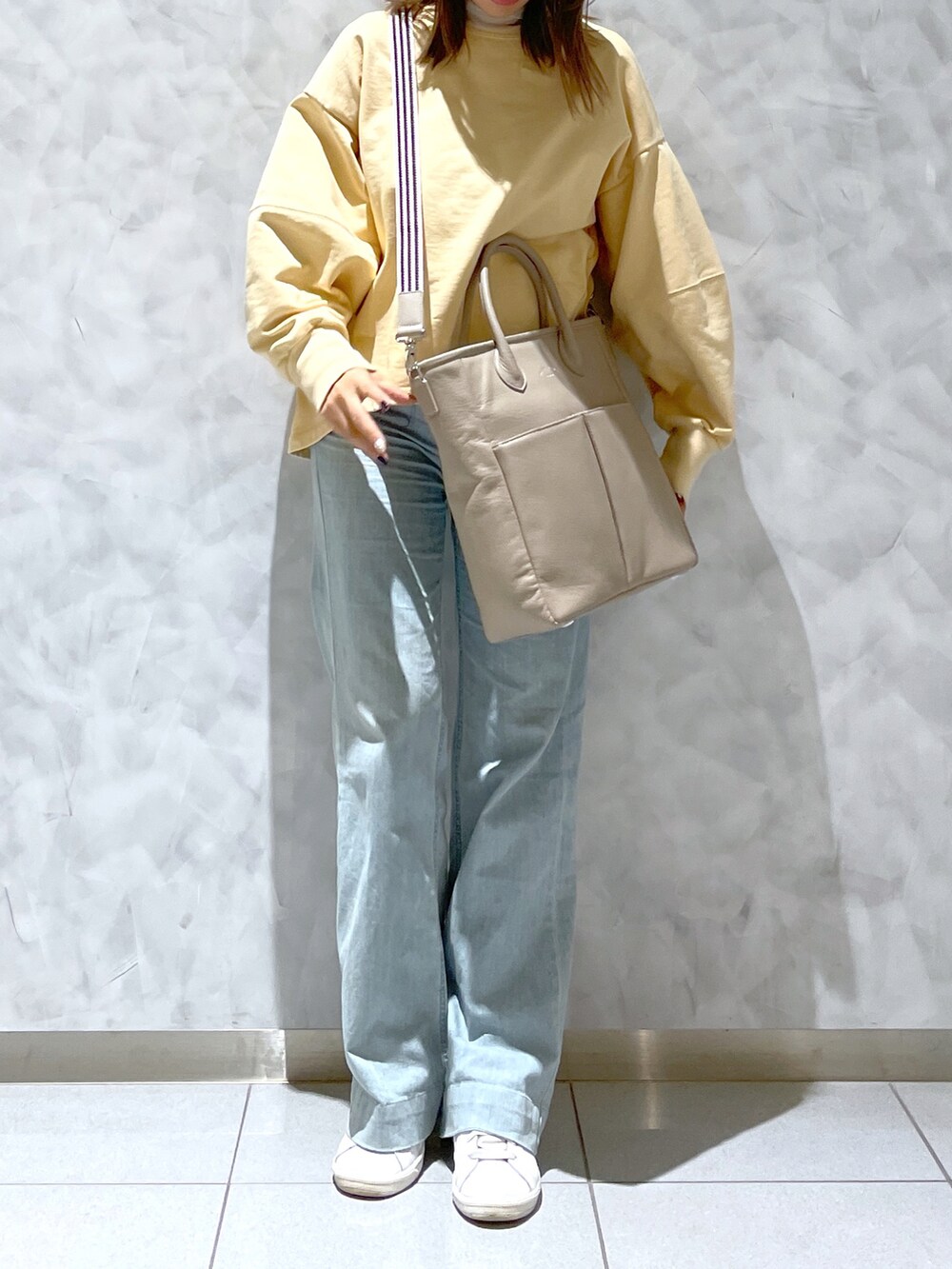 ベージュ系のトートバッグを着用したレディースの冬コーディネートの3枚目の写真